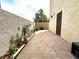 Narrow brick patio with desert landscaping along the wall with a tan colored stucco wall at 10372 Beautiful Fruit St, Las Vegas, NV 89183