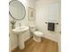 Stylish powder room with pedestal sink, round mirror, and modern fixtures at 10372 Beautiful Fruit St, Las Vegas, NV 89183