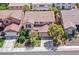 Aerial shot of this lovely home with a red tiled roof, surrounded by lush landscaping and neighboring properties at 10409 Snowdon Flat Ct, Las Vegas, NV 89129