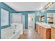 Bathroom featuring a tub with shower, double sinks, and blue-painted walls at 10409 Snowdon Flat Ct, Las Vegas, NV 89129