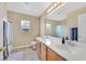 Bright bathroom featuring dual sinks with a large mirror, and separate shower area at 10409 Snowdon Flat Ct, Las Vegas, NV 89129