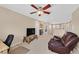 Living room featuring comfortable seating, ceiling fan, and neutral carpeting at 10409 Snowdon Flat Ct, Las Vegas, NV 89129