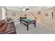 Open living area features a billiard table, comfortable sofa, and a staircase to the second floor at 10409 Snowdon Flat Ct, Las Vegas, NV 89129