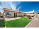 Backyard with artificial grass, desert landscaping, and a paved patio at 1043 Armillaria St, Henderson, NV 89011