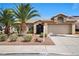 Charming single-story home with desert landscaping, mature palm trees, and a two-car garage at 1043 Armillaria St, Henderson, NV 89011