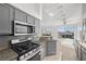 Open kitchen with a stainless steel range, microwave, and granite countertops at 1043 Armillaria St, Henderson, NV 89011