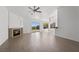 Open-concept living room with fireplace, ceiling fan, hardwood floors and sliding doors to the backyard at 1043 Armillaria St, Henderson, NV 89011