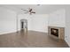 Spacious living room boasts hardwood floors, a ceiling fan, and fireplace with decorative tile surround at 1043 Armillaria St, Henderson, NV 89011