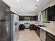 Kitchen featuring stainless steel appliances, dark wood cabinets, and a tile floor at 10609 Sand Mountain Ave, Las Vegas, NV 89166