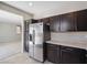 Modern kitchen featuring stainless steel refrigerator, dark wood cabinets, and neutral countertops at 10609 Sand Mountain Ave, Las Vegas, NV 89166