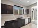 Well-lit kitchen boasting dark wood cabinetry, white countertops, and modern sink at 10609 Sand Mountain Ave, Las Vegas, NV 89166