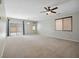 Spacious living room with neutral carpet, a ceiling fan, and sliding glass doors to the outside at 10609 Sand Mountain Ave, Las Vegas, NV 89166