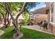 Inviting backyard features a covered patio with elegant stone pavers and lush green grass at 11294 Corsica Mist Ave, Las Vegas, NV 89135