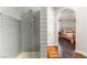 Bathroom featuring sleek gray subway tiles in shower and an open doorway to bedroom at 11294 Corsica Mist Ave, Las Vegas, NV 89135