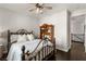 This charming bedroom features a decorative iron bed frame, ceiling fan, and dark wood floors at 11294 Corsica Mist Ave, Las Vegas, NV 89135