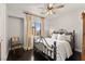 Charming bedroom featuring a decorative iron bed frame, wooden floors and a ceiling fan at 11294 Corsica Mist Ave, Las Vegas, NV 89135