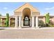 Stunning clubhouse entrance shows grand archway, columns, and manicured landscaping at 11294 Corsica Mist Ave, Las Vegas, NV 89135