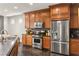 Well-equipped kitchen with stainless steel appliances, wood cabinets, and dark countertops at 11294 Corsica Mist Ave, Las Vegas, NV 89135