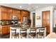 Stylish kitchen with dark countertops, wooden cabinetry, and bar stool seating at the island at 11294 Corsica Mist Ave, Las Vegas, NV 89135