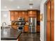 A kitchen with stainless steel appliances, wood cabinetry, and black countertops at 11294 Corsica Mist Ave, Las Vegas, NV 89135