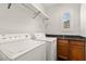Bright laundry room with a washer, dryer, shelving, and natural light from a window at 11294 Corsica Mist Ave, Las Vegas, NV 89135