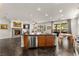 Open-concept living room with fireplace, kitchen island, and access to an outdoor patio at 11294 Corsica Mist Ave, Las Vegas, NV 89135