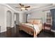 Comfortable main bedroom with a ceiling fan, tray ceiling, windows and hardwood floors at 11294 Corsica Mist Ave, Las Vegas, NV 89135