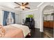 Comfortable main bedroom with a ceiling fan, tray ceiling, windows and hardwood floors at 11294 Corsica Mist Ave, Las Vegas, NV 89135