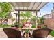 Backyard patio featuring a pergola, comfortable seating, green grass and landscaping at 11294 Corsica Mist Ave, Las Vegas, NV 89135
