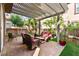 Covered patio with comfortable seating, overhead lighting, and a beautifully landscaped backyard at 11294 Corsica Mist Ave, Las Vegas, NV 89135