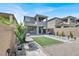 Home's landscaped backyard featuring gravel, artificial turf, covered patio, and a hanging chair at 12426 Oregon Cherry Ave, Las Vegas, NV 89138