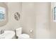 Bright bathroom featuring a toilet, sink, decorative mirror, and a stylish, eye-catching stained glass window at 12426 Oregon Cherry Ave, Las Vegas, NV 89138