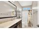 Modern bathroom featuring a vanity with stone countertop, decorative mirror, and a shower-tub combo at 12426 Oregon Cherry Ave, Las Vegas, NV 89138