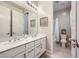 Bright bathroom featuring double sinks, white cabinets, and a separate toilet and shower area at 12532 Blissful Sky St, Las Vegas, NV 89138
