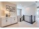 Upstairs hallway with a modern railing, white cabinets, and tasteful decor at 12532 Blissful Sky St, Las Vegas, NV 89138