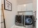 Well-equipped laundry room with modern washer and dryer units and storage cabinets at 12532 Blissful Sky St, Las Vegas, NV 89138