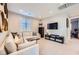 Cozy living room featuring a white sectional sofa, media center, and plenty of natural light at 12532 Blissful Sky St, Las Vegas, NV 89138