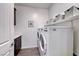 Well-organized laundry room with washer, dryer, storage shelves and a utility sink at 1319 Yosemite St, Boulder City, NV 89005