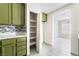 Pantry storage with tiled floors, marble countertops, mosaic backsplash and olive green cabinetry at 1400 Jamielinn Ln # 104, Las Vegas, NV 89110