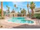 Community pool with lounge area surrounded by palm trees and lush landscaping offers a resort-style atmosphere at 1400 Jamielinn Ln # 104, Las Vegas, NV 89110