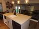 Well-lit kitchen includes island seating with modern lighting, black hardware, and modern appliances at 1508 Silver Knoll Ave, Las Vegas, NV 89123
