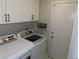 Well-equipped laundry area with white appliances, built-in cabinets, and storage basket at 1508 Silver Knoll Ave, Las Vegas, NV 89123