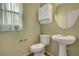 Half bath features a pedestal sink, window, and modern fixtures and hardware at 165 Calm Morning Ave, Henderson, NV 89002