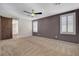 Spacious bedroom with carpet, ceiling fan, barn door to bath, and plantation shutters at 165 Calm Morning Ave, Henderson, NV 89002