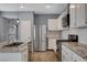 This kitchen includes white cabinets, modern appliances, granite countertops, and tiled backsplash at 165 Calm Morning Ave, Henderson, NV 89002