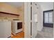 Laundry room featuring a washer, dryer, and shelving with door to adjacent bedroom at 165 Calm Morning Ave, Henderson, NV 89002