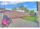 A quaint backyard offers a brick privacy wall, potted plants, and seating around an artificial lawn at 2104 Leatherbridge Ct, North Las Vegas, NV 89081