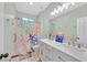 Bright bathroom with double sink vanity, modern lighting and decorative shower curtain at 2104 Leatherbridge Ct, North Las Vegas, NV 89081
