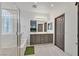 Bathroom with double sink vanity and glass-enclosed shower and tub at 2104 Leatherbridge Ct, North Las Vegas, NV 89081