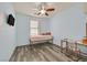 Cozy bedroom featuring a simple bed frame and a ceiling fan and desk area at 2104 Leatherbridge Ct, North Las Vegas, NV 89081